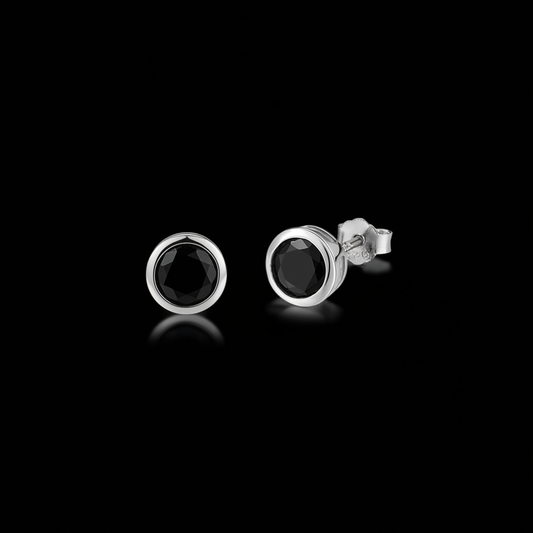 Pair of black onyx bezel-set stud earrings on a black background